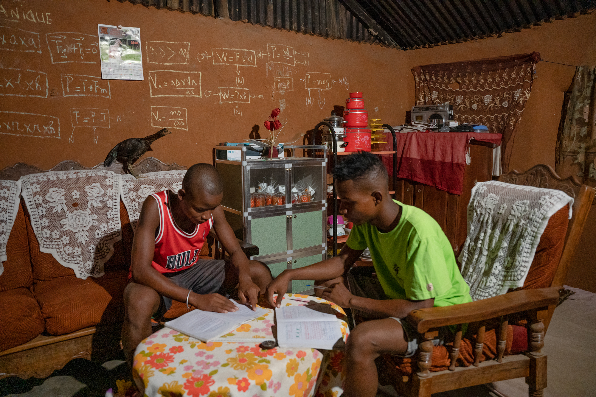 Tovondray and Lahininik, two young Malagasy study in their living room.